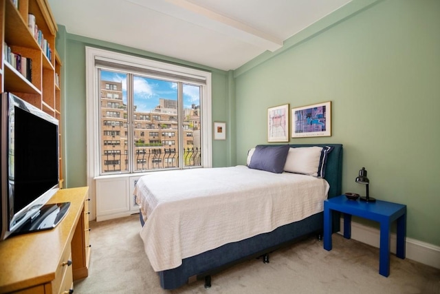 bedroom with beam ceiling and light carpet