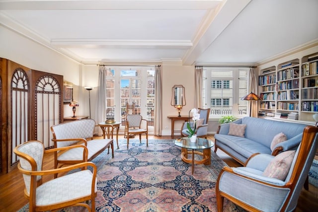 sitting room with ornamental molding, wood-type flooring, and beam ceiling