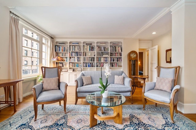 sitting room with crown molding and light wood-type flooring