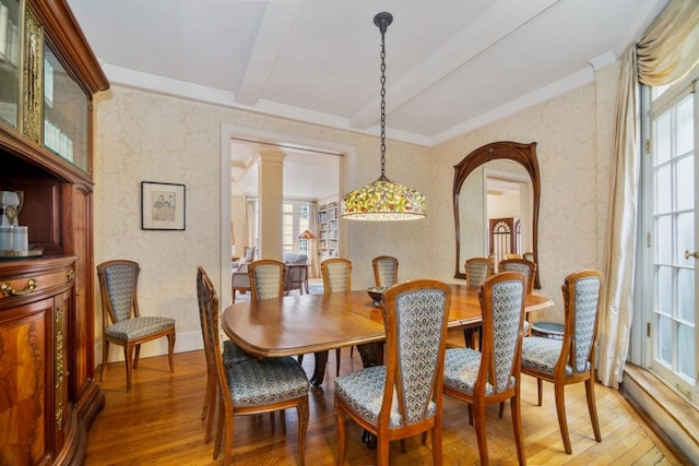 dining area featuring wood-type flooring, plenty of natural light, and beam ceiling