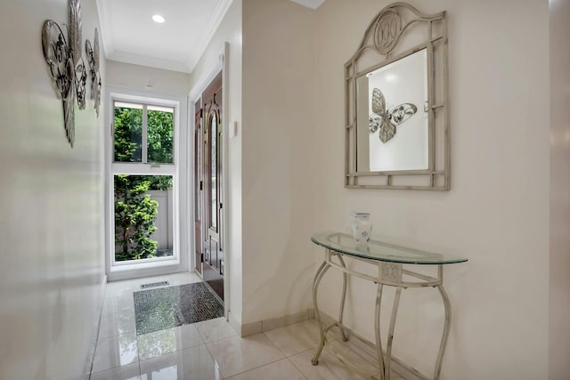 foyer entrance featuring light tile patterned floors, visible vents, baseboards, and ornamental molding