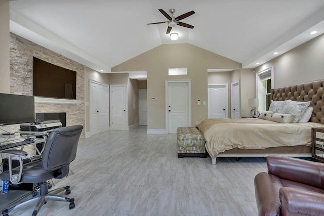 bedroom featuring wood finished floors, baseboards, ceiling fan, vaulted ceiling, and connected bathroom