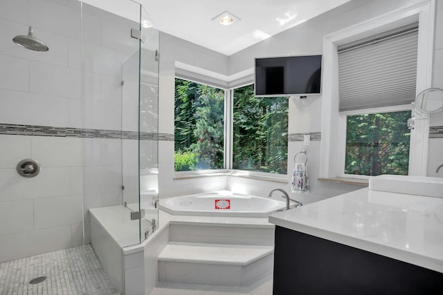 full bathroom with vanity, a garden tub, and a shower stall