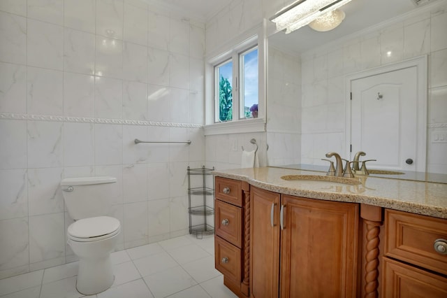 bathroom with toilet, ornamental molding, tile walls, tile patterned flooring, and vanity