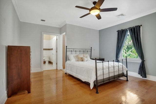 bedroom with visible vents, baseboards, wood finished floors, and ornamental molding