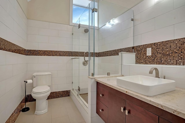 full bathroom featuring tile patterned flooring, tile walls, toilet, and a shower stall