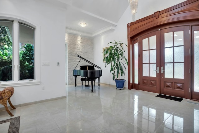 foyer entrance featuring french doors, crown molding, and baseboards