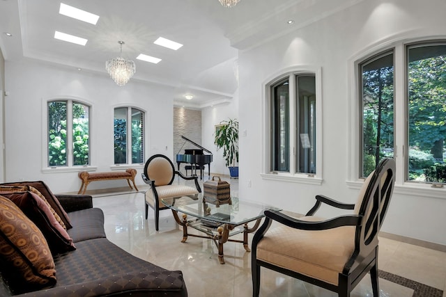 living room featuring crown molding, baseboards, a chandelier, a skylight, and marble finish floor