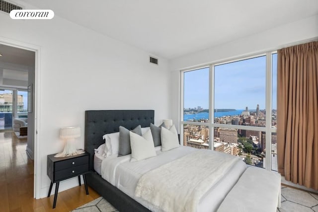 bedroom featuring a water view and light hardwood / wood-style floors