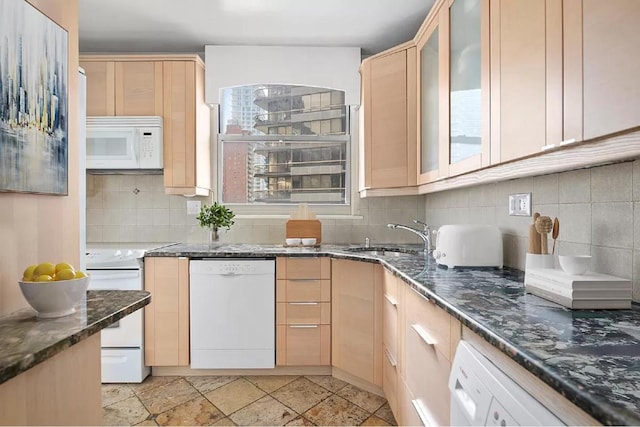 kitchen with light brown cabinetry, sink, dark stone countertops, backsplash, and white appliances