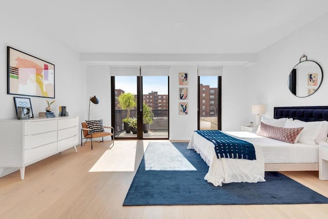 bedroom with access to outside and light hardwood / wood-style flooring