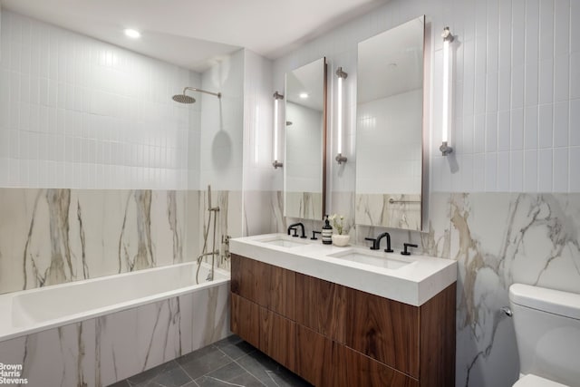 full bathroom featuring tile walls, tile patterned flooring, tiled shower / bath combo, vanity, and toilet