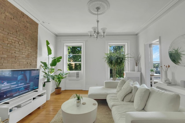 living room with crown molding, plenty of natural light, light hardwood / wood-style flooring, and a notable chandelier