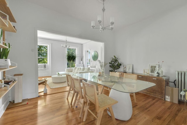 dining room with radiator, a chandelier, and light hardwood / wood-style floors