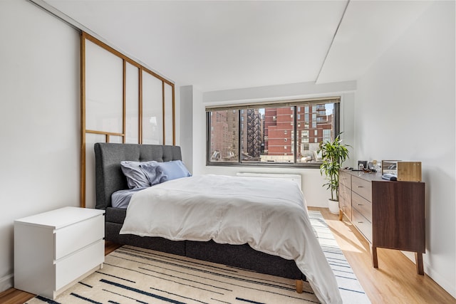 bedroom featuring radiator and light hardwood / wood-style flooring