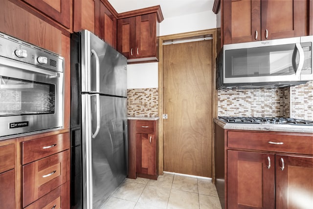 kitchen featuring stainless steel appliances, light tile patterned flooring, and decorative backsplash