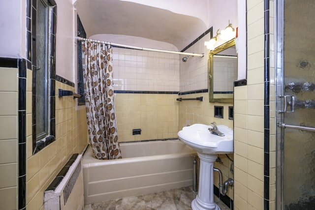 bathroom with radiator heating unit, tile walls, and shower / bath combo with shower curtain