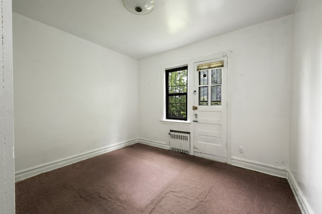 spare room with carpet flooring and radiator