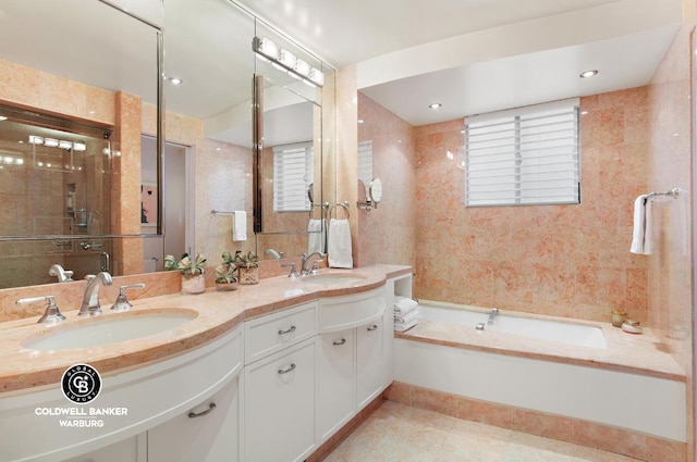 bathroom featuring tile walls, a tub to relax in, vanity, and tile patterned flooring