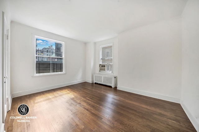 spare room with radiator and dark hardwood / wood-style flooring