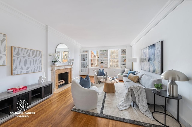 living room with built in shelves, crown molding, and hardwood / wood-style floors