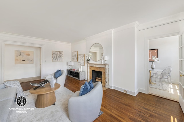 living room featuring ornamental molding, a fireplace, dark wood finished floors, and baseboards