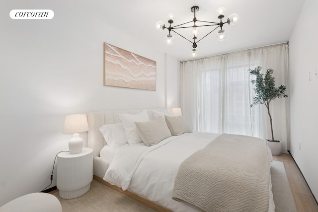 350 W 44th St Unit 101, New York City, NY 10036 - bedroom featuring a chandelier and light wood-style floors