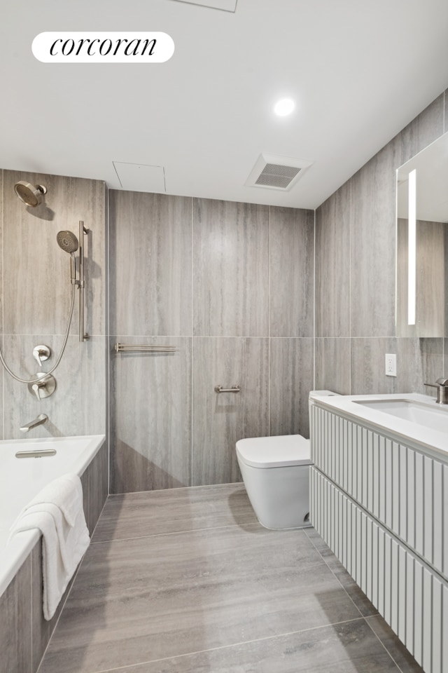 350 W 44th St Unit 101, New York City, NY 10036 - bathroom with tile walls, toilet, vanity, and tiled shower / bath