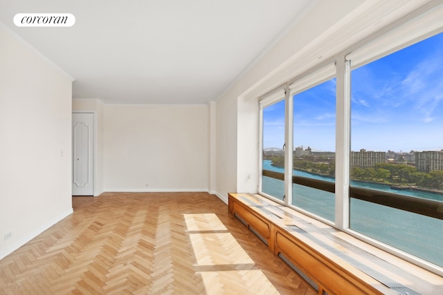 empty room featuring a water view, visible vents, and baseboards