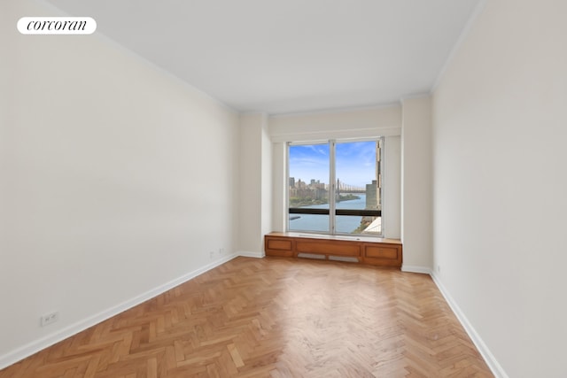 spare room featuring crown molding, light parquet flooring, and a water view