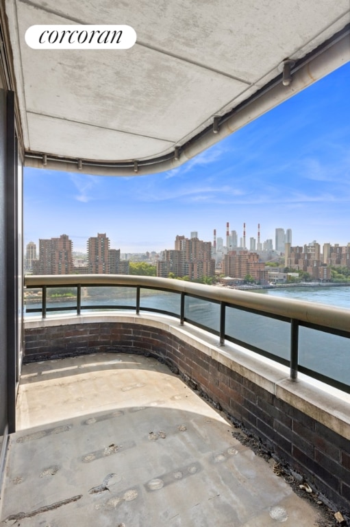 view of patio with a water view and a balcony