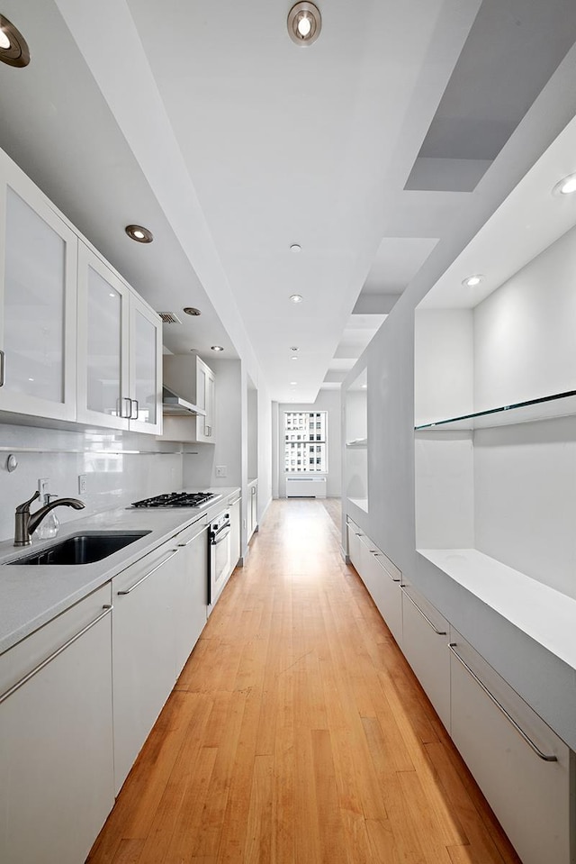 15 Broad St Unit 2206, New York City, NY 10005 - kitchen featuring a sink, white cabinetry, light countertops, gas cooktop, and recessed lighting