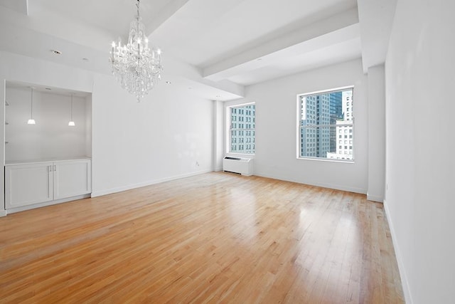 15 Broad St Unit 2206, New York City, NY 10005 - unfurnished room with light wood-type flooring, a chandelier, baseboards, and a wall unit AC