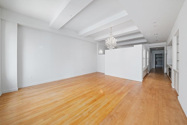 15 Broad St Unit 2206, New York City, NY 10005 - empty room with a chandelier, light wood-style flooring, beamed ceiling, and baseboards