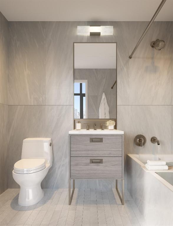 full bathroom with tile walls, vanity, tub / shower combination, and toilet