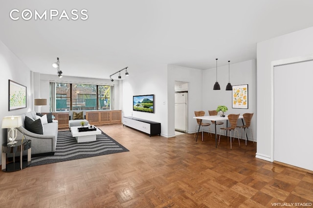 living room featuring parquet flooring and track lighting