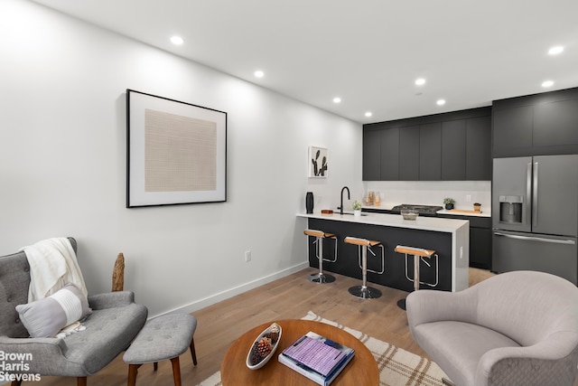 living room featuring sink and light hardwood / wood-style floors