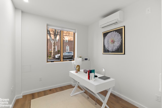 home office with wood-type flooring and a wall unit AC