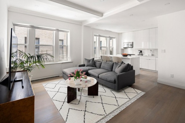 living room with baseboards, wood finished floors, and beamed ceiling