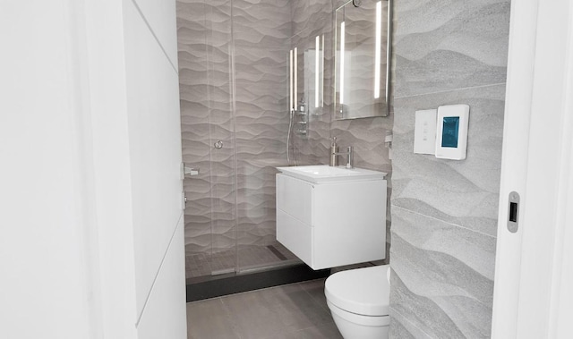 bathroom featuring toilet, tile patterned floors, tile walls, and vanity