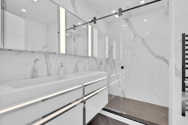 bathroom with a marble finish shower and vanity