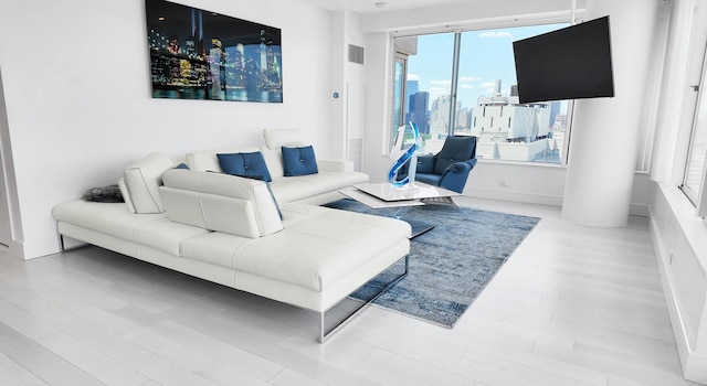 living area featuring visible vents and wood finished floors