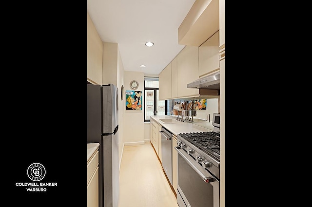 kitchen with appliances with stainless steel finishes, sink, and cream cabinets