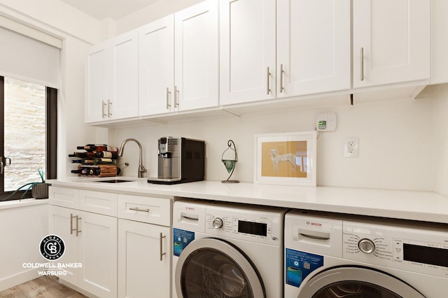 laundry room featuring sink, washing machine and clothes dryer, and cabinets