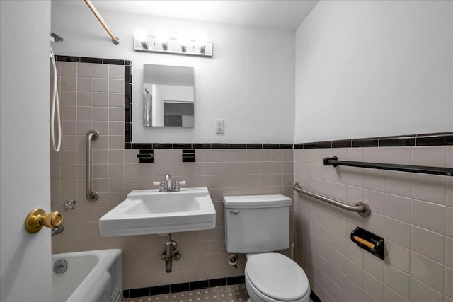 bathroom featuring toilet, tile walls, and sink