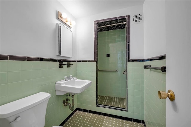 2727 Palisade Ave Unit 7-B, New York City, NY 10463 - bathroom featuring tile walls, a tile shower, a sink, toilet, and wainscoting