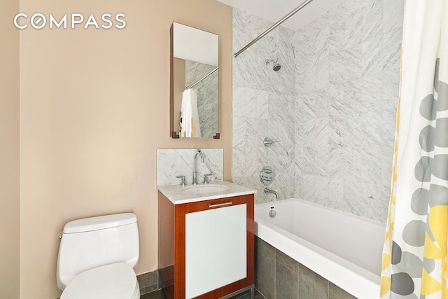 bathroom featuring decorative backsplash, toilet, vanity, and tiled shower / bath combo