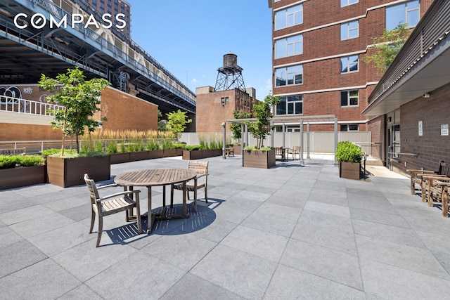 view of patio featuring outdoor dining space and fence