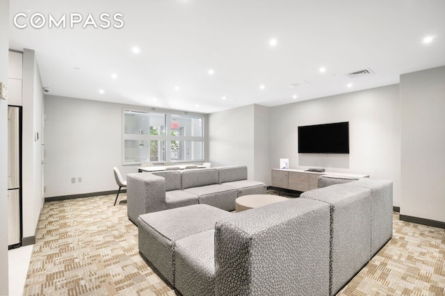 living area with recessed lighting, visible vents, and baseboards