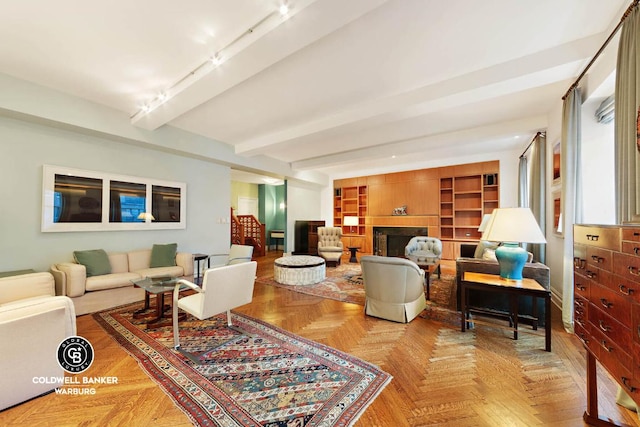 living room featuring parquet floors, a fireplace, and beamed ceiling